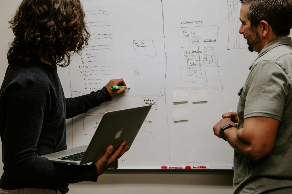 Digital marketing professionals brainstorming on a glass board